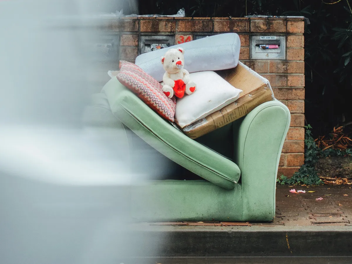Image of a chair and cushions on the side of the road for disposal