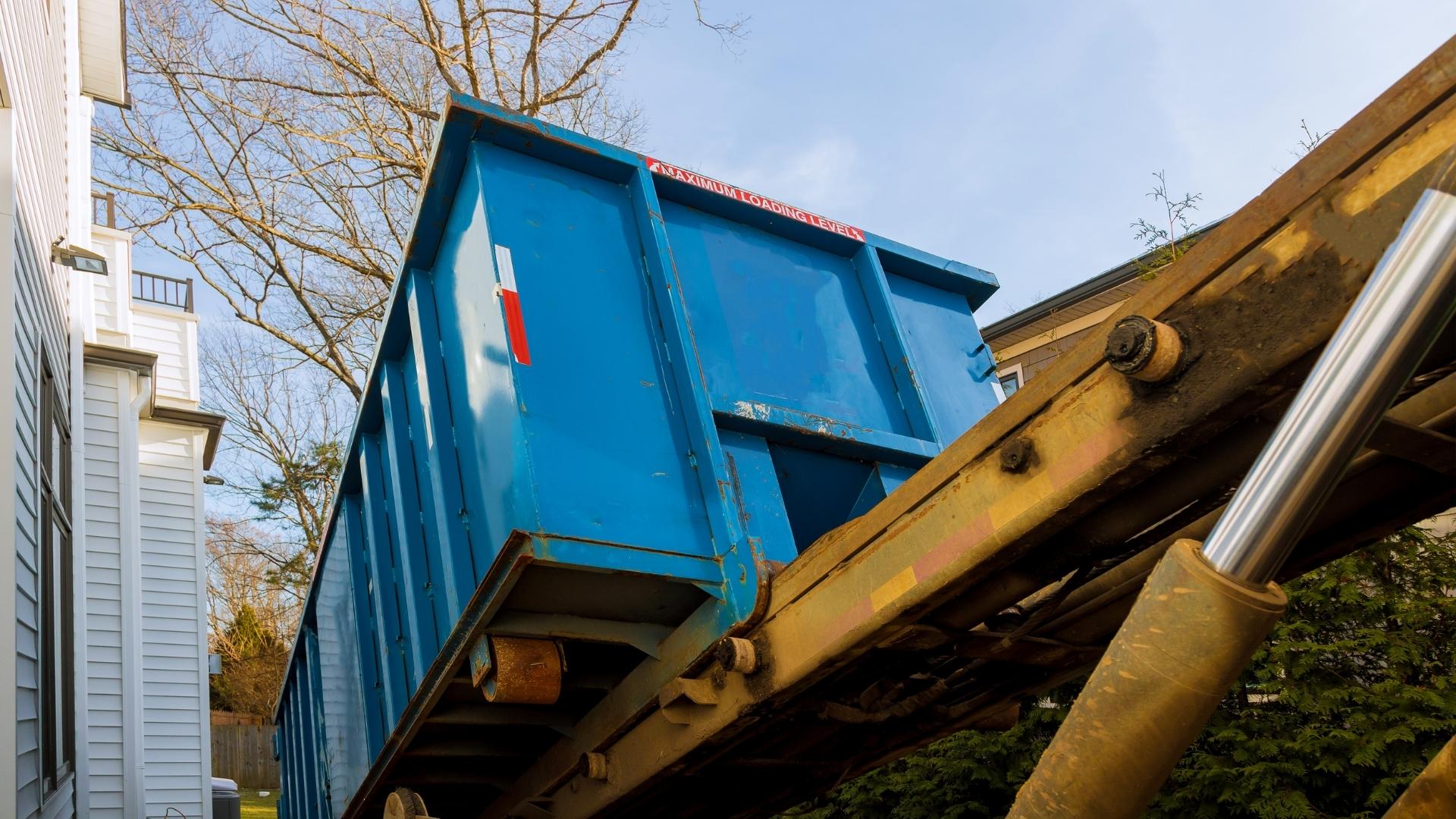 roll off dumpster being unloaded from truck